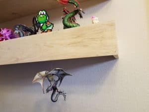 Hanging decorations under a floating shelf.